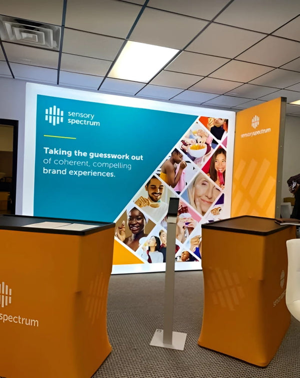 Orange fabric-covered SEG lightbox stands with Sensory Spectrum logo