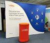 Orange cylindrical Unblu branded trash can in 10ft Straight Pop Up Fabric Display