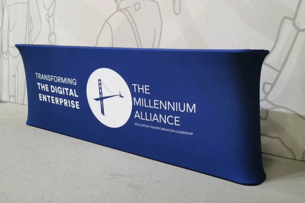 Blue stretch banner with white Millennium Alliance text and logo on 10ft straight tension fabric counter