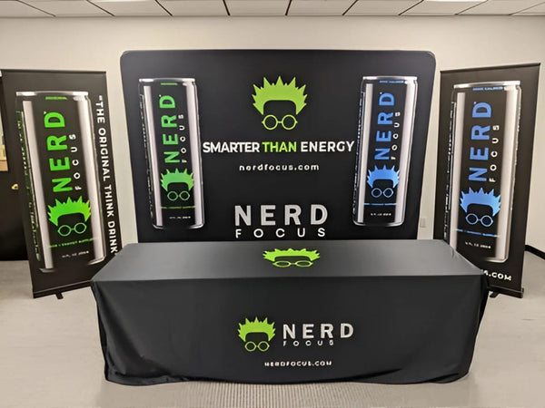 10ft Straight Tension Fabric Display with green Nerd Focus logo on black tablecloth