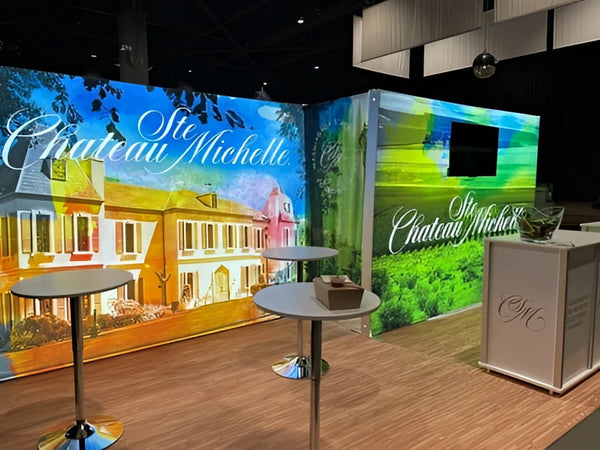 White rectangular trade show booth counter with silver c&g logo on 10x10 SEG lightbox