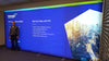 Man in front of 20ft Backlit Tension Fabric Display Kit with Intrado presentation