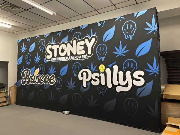 Black banner with blue cannabis leaf, smiley patterns, Stoney the Higher Standard text for Briscoe Psillys 20ft pop up display