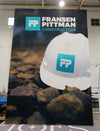 White hard hat with teal logo on 5ft straight pop up fabric display