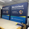 Blue and teal Merrick Bank merchant display stand with yellow accents, 5ft tabletop pop-up fabric