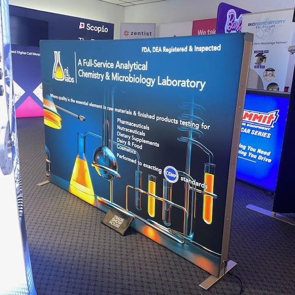 Blue lab lightbox banner with beakers, flasks, orange liquid