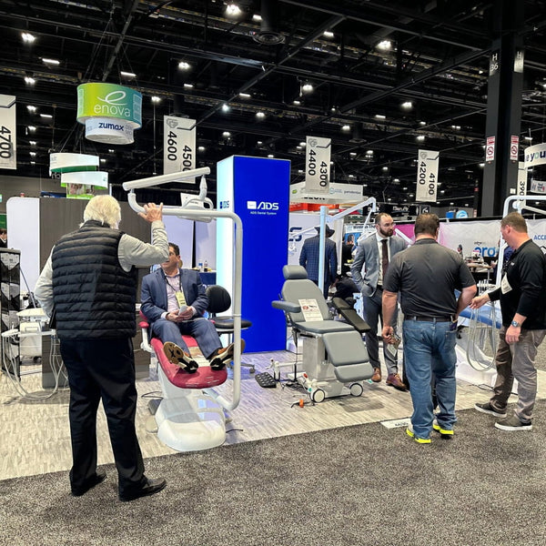 Gray and white reclining dental chair with adjustable armrests