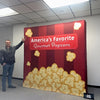 Red and gold popcorn backdrop with Americas Favorite Gourmet Popcorn text