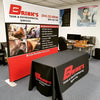 Black tablecloth with red Brinks Tank & Environmental Services logo on 8ft display