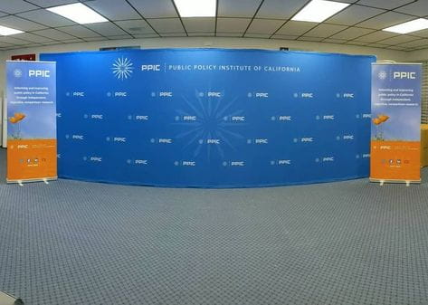Blue curved backdrop with PPIC logo and Public Policy Institute of California text on Classic 33 Inch Retractable Banner Stand