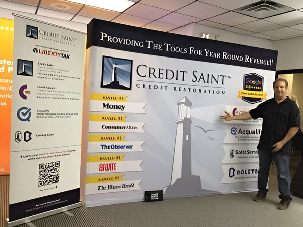 Man in black shirt beside Credit Saint lighthouse banner stand