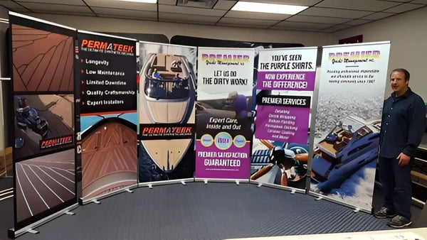 Man beside Permateek promotional banners on Classic 33 Inch retractable stand