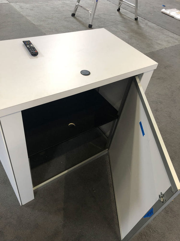 White metal single-door cabinet with black interior and blue edge tape for desk grommet