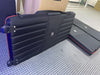 Black ribbed hard-shell suitcase with red zipper and blue wheels