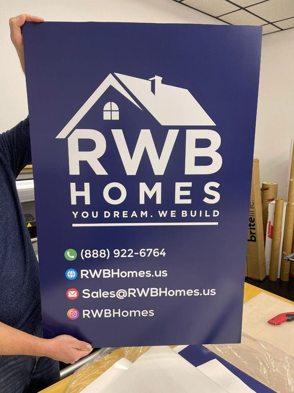 Blue RWB Homes promotional sign with white house logo and contacts