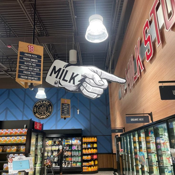 Illustrated hand pointing to milk section in grocery store poster