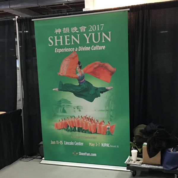 Green Shen Yun 2017 roll-up banner with mid-air dancer in red green costumes