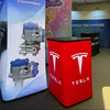 Red Tesla branded display stand on Square Backlit Inflatable Counter