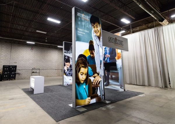 Tall silver Sync 2-in-1 backlit hybrid island exhibit with Stienel logo