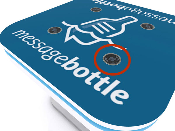 Blue MessageBottle device with white logo and three sensors in wireless charging kit