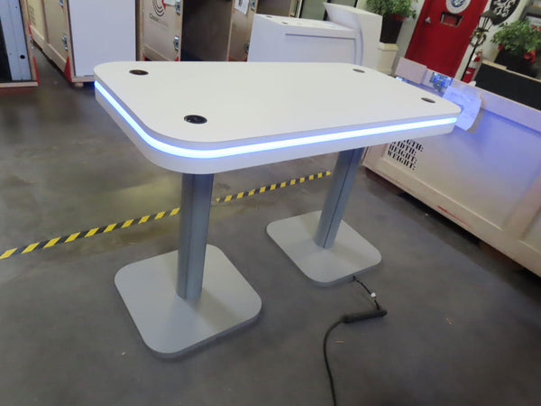 Modern white table with illuminated edge and gray pedestal legs for wireless charging kit
