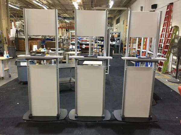 Three identical X6 beige and silver mobile podiums with black wheels