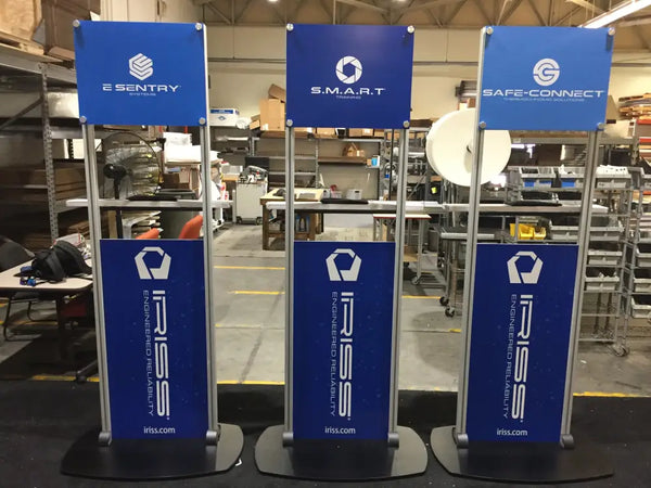 Three blue X6 Freestanding TV Monitor Stands with silver frames, black bases, and e sentry, s.m.a.r.t., safe-connect logos