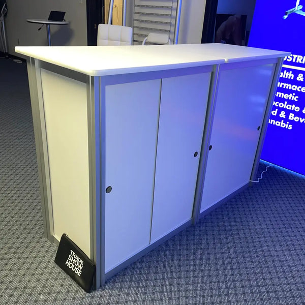 XRC9 Backlit Storage Counter with white top, silver cabinets, black handles