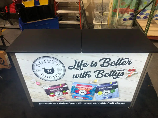 Black countertop display stand with Bettys Eddies branding in XRC9 Backlit Storage Counter