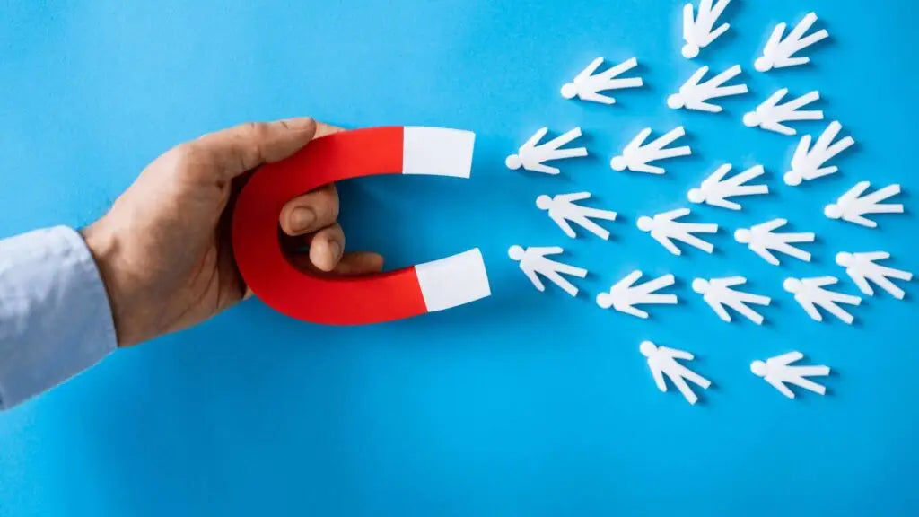 Hand holding red white magnet attracting paper figures at trade shows