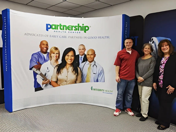 Blue and white curved banner with Partnership Health Center logo and smiling healthcare professionals for 10ft pop up display kit