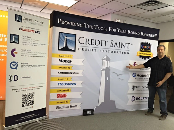 Man holding white and red credit card in 10ft pop up display kit