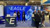Blue eagle booth with white logo, green swoosh, and microbe testing equipment in 20ft light box wall