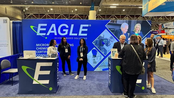 Blue eagle booth with white logo, green swoosh, and microbe testing equipment in 20ft light box wall
