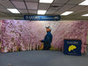 Man in blue jacket under pink cherry blossom backdrop for 20ft curved display