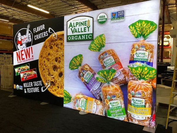 Alpine Valley organic bread loaves in colorful leaf-topped packaging with USDA seals in 20ft frameless SEG lightbox