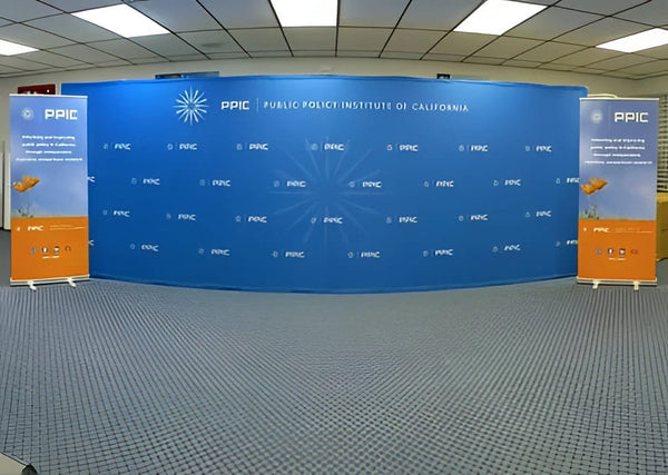 Blue curved backdrop with PPIC logo and text for Public Policy Institute of California on 20ft straight pop up display
