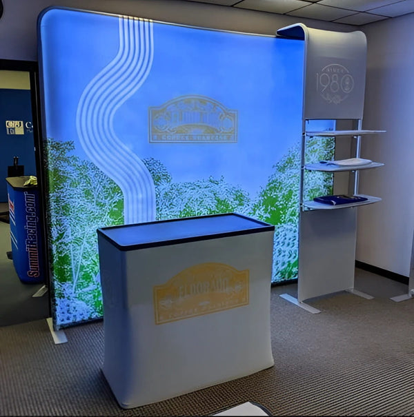 36’’ Partial Waterfall Shelving Display with white fabric booth and illuminated blue-green logo backdrop