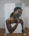 White Circadia standee woman with braided hair applying face mask