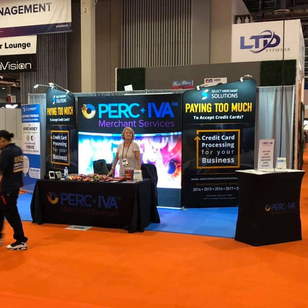 Black tablecloth with Perc+iva Merchant Services blue-white logo on 5ft x 8ft angled tension fabric display