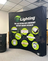 8ft Curved Pop Up Fabric Display with black curved banner, green icons, white e2 lighting promo text