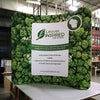 8ft Curved Tension Fabric Display with green leaf-patterned backdrop and Leaves Inspired Tree Nursery logo