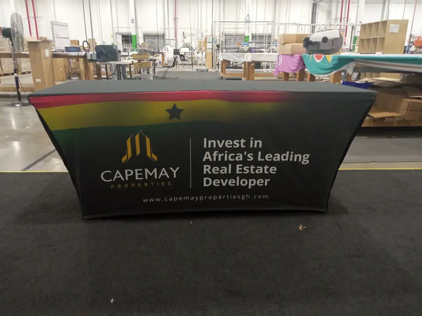 Black stretch table cover with Ghanaian flag colors and CapeMay Properties logo