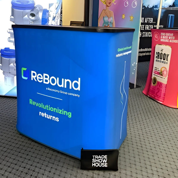 Blue rebound trade show display box with white and green branding