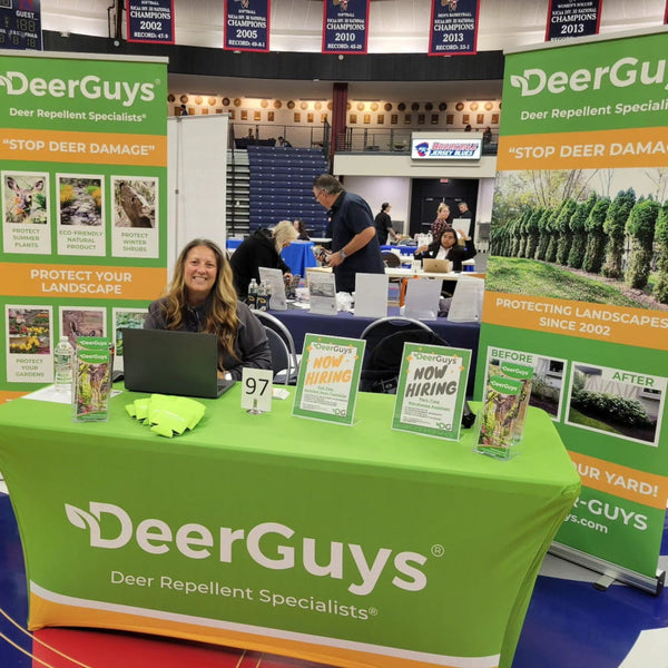 Stretch table cover with green tablecloth, white and orange trim, and Deerguys logo