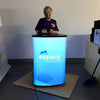 Blue illuminated cylindrical display stand with Prevail Infoworks logo